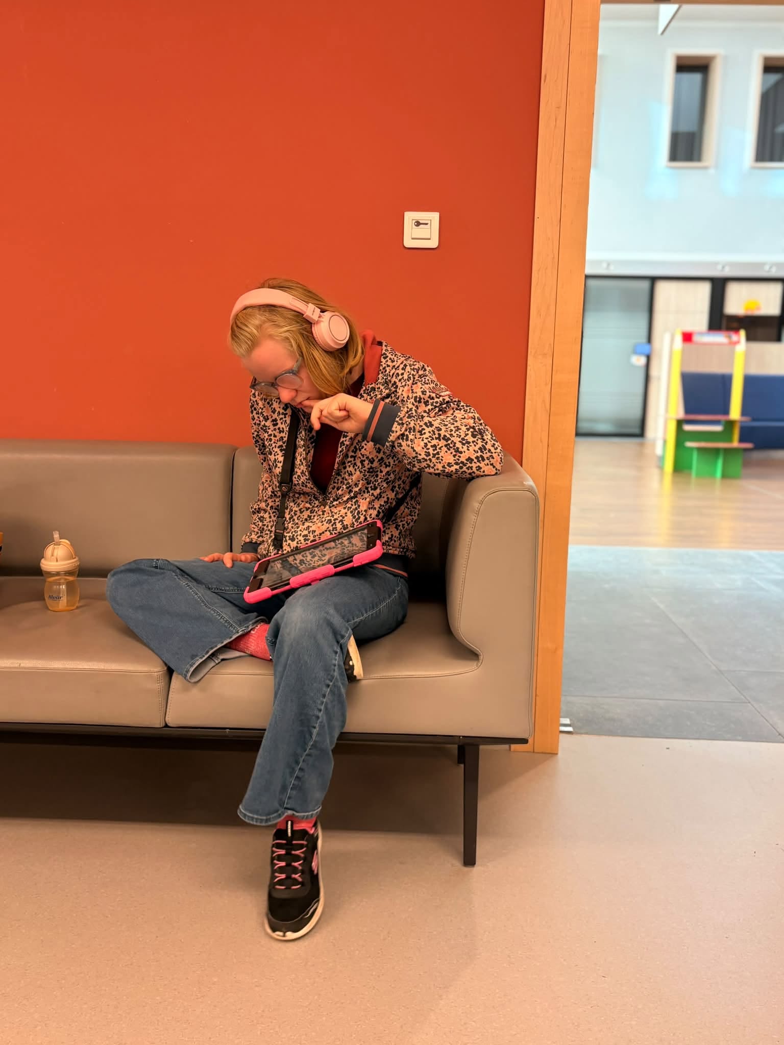 Elise assise sur un canapé en salle d'attente